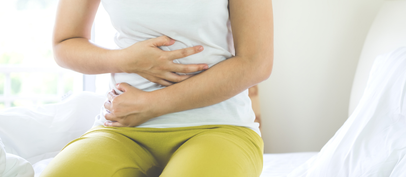 Frau hat Bauchschmerzen sitzt auf Bett Endometriose